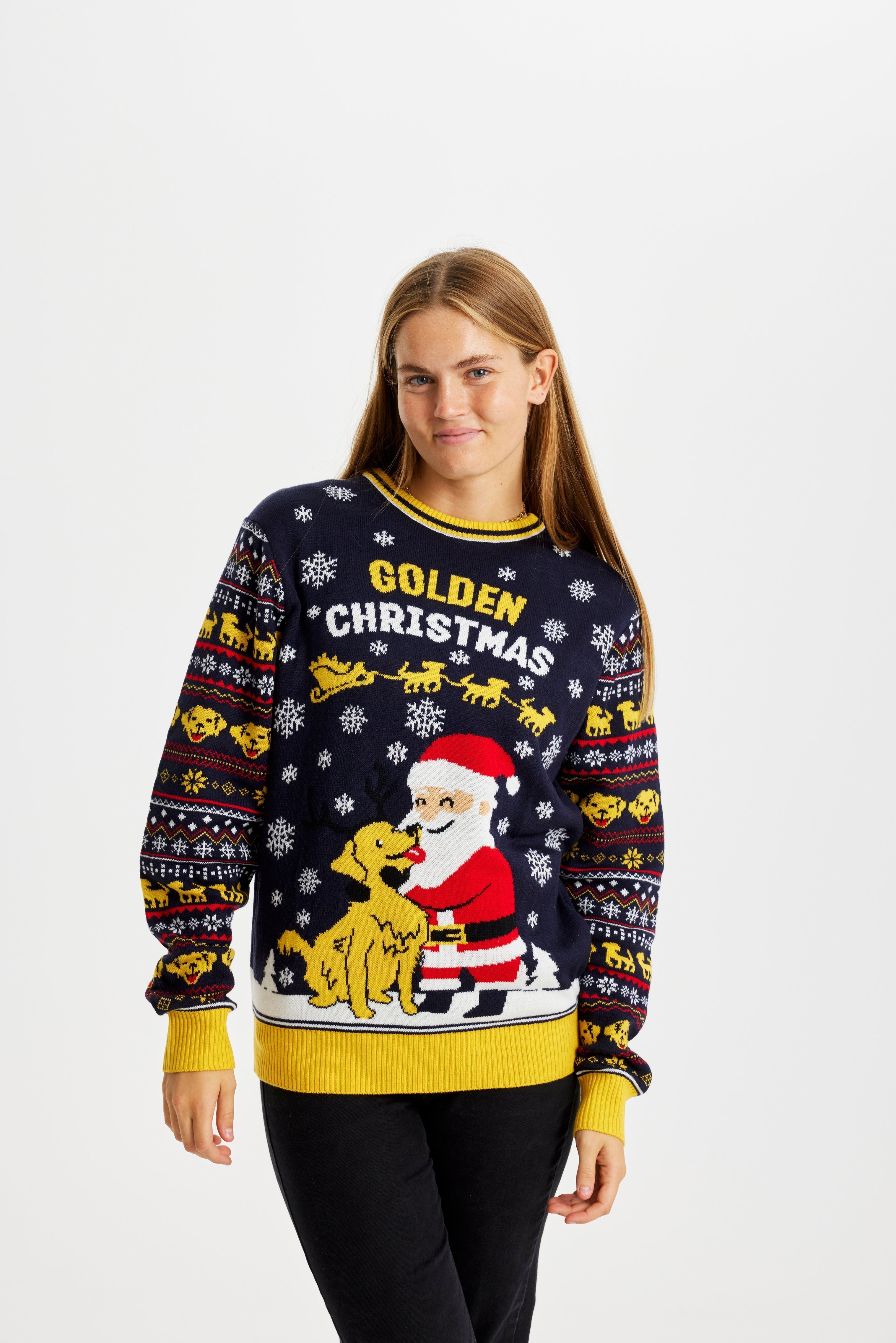 Una donna che indossa un maglione natalizio giallo e blu con un Babbo Natale e un cane.